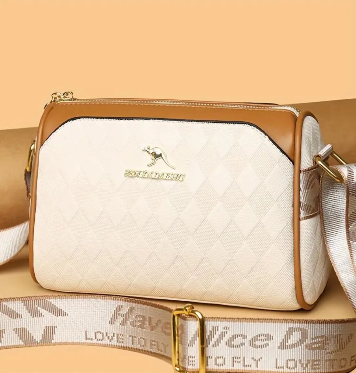 Front view of TRENDBUY cream geometric Boston sling bag, emphasizing textured pattern and broad strap.
