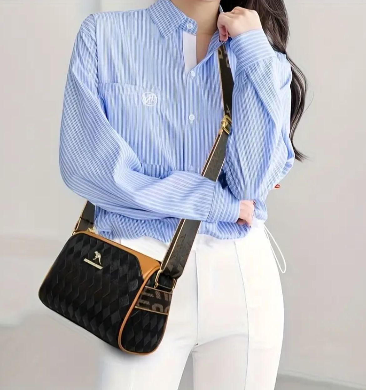 Model showcasing TRENDBUY black geometric sling bag worn as a crossbody with a striped shirt and white pants.