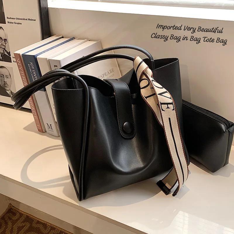 TRENDBUY classic black 2-piece PU leather tote bag set with a 'LOVE' strap and matching utility pouch, positioned next to books.