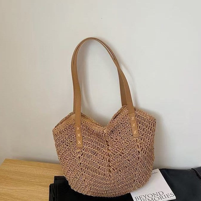 Natural brown TRENDBUY woven tote bag with contrasting brown handles, displayed on a wooden surface.