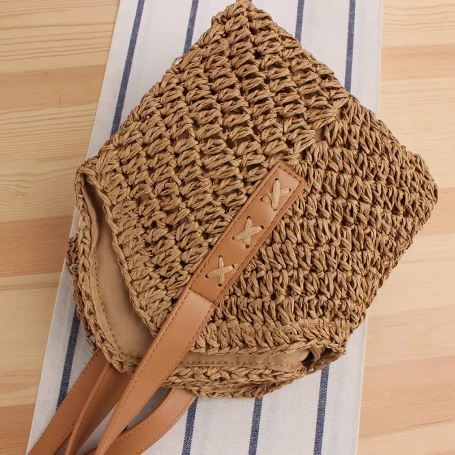 Close-up detail of the natural brown TRENDBUY woven tote bag, featuring the durable texture and reinforced handle attachment with decorative X-stitching.
