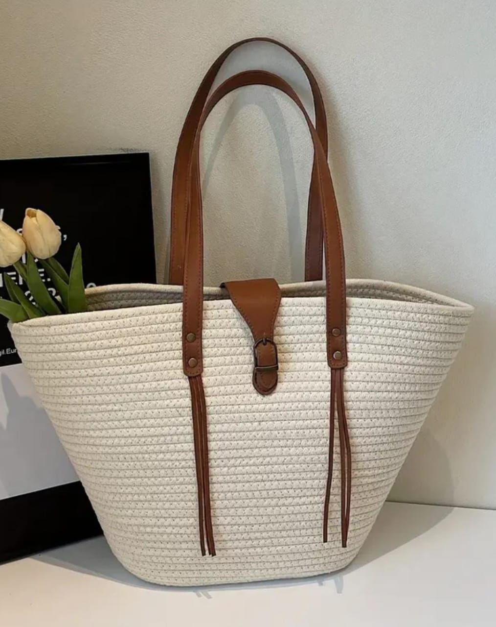 Frontal view of the TRENDBUY white woven tote, showcasing its trapezoidal shape and brown strap accents.