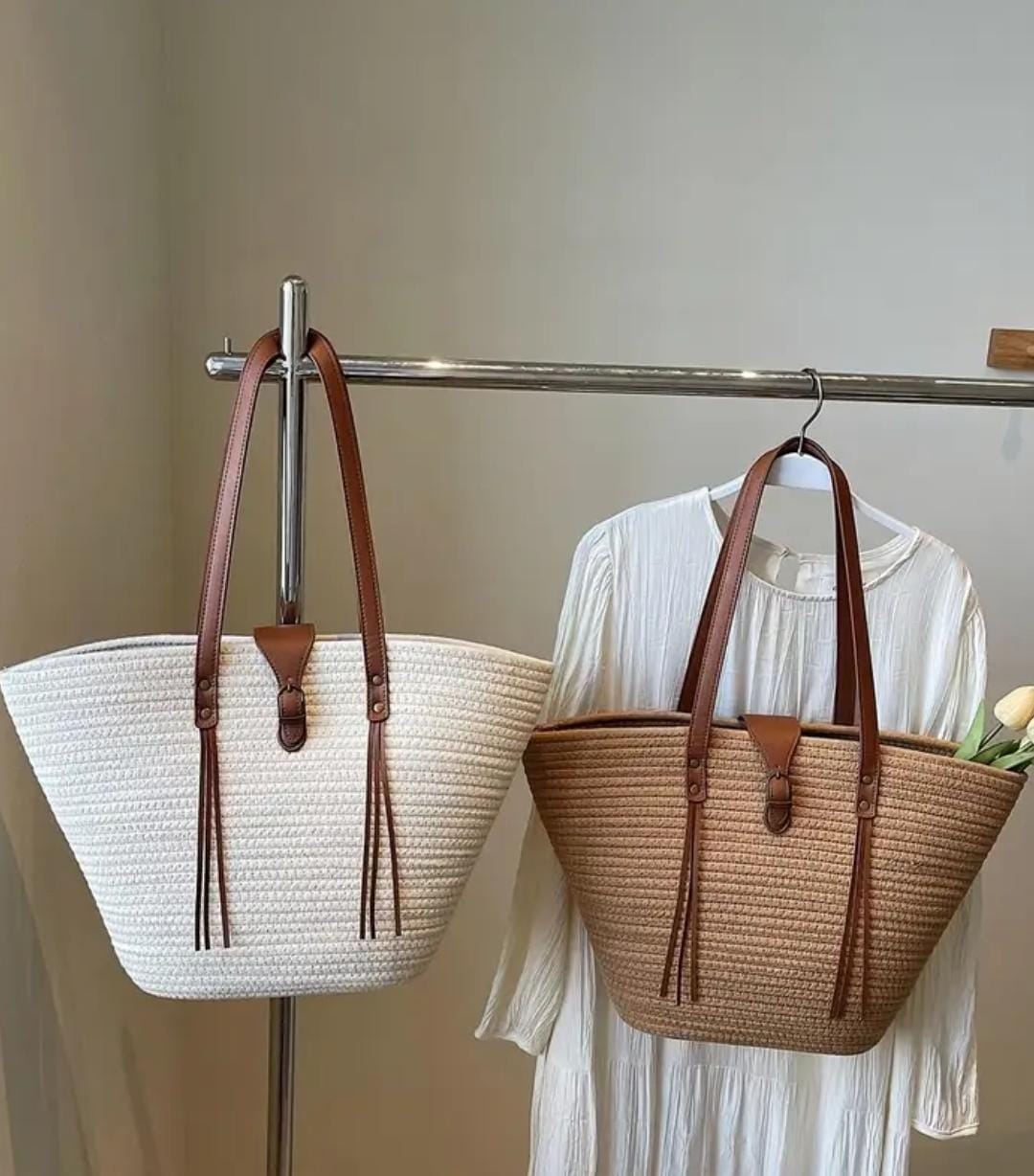 Two TRENDBUY straw weave tote bags, one white and one beige, hanging on a retail display rack.