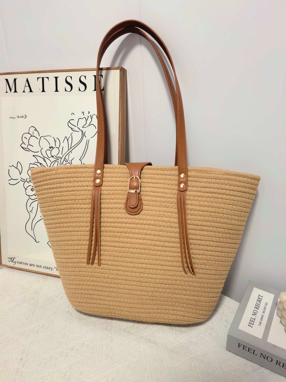 TRENDBUY beige straw weave tote bag in a stylish interior setting with a Matisse print backdrop.