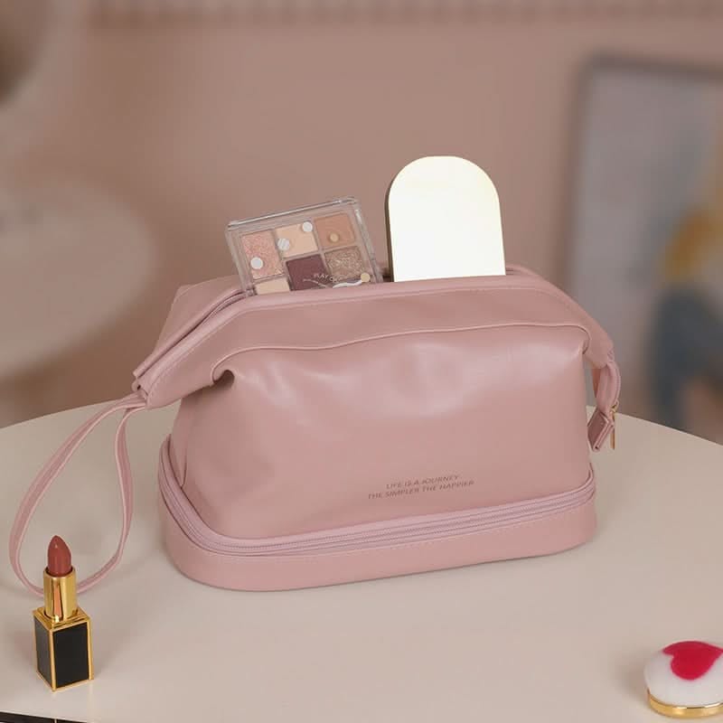 Pink double-layer makeup bag on a vanity table with eyeshadow palette and small mirror inside, lipstick nearby.