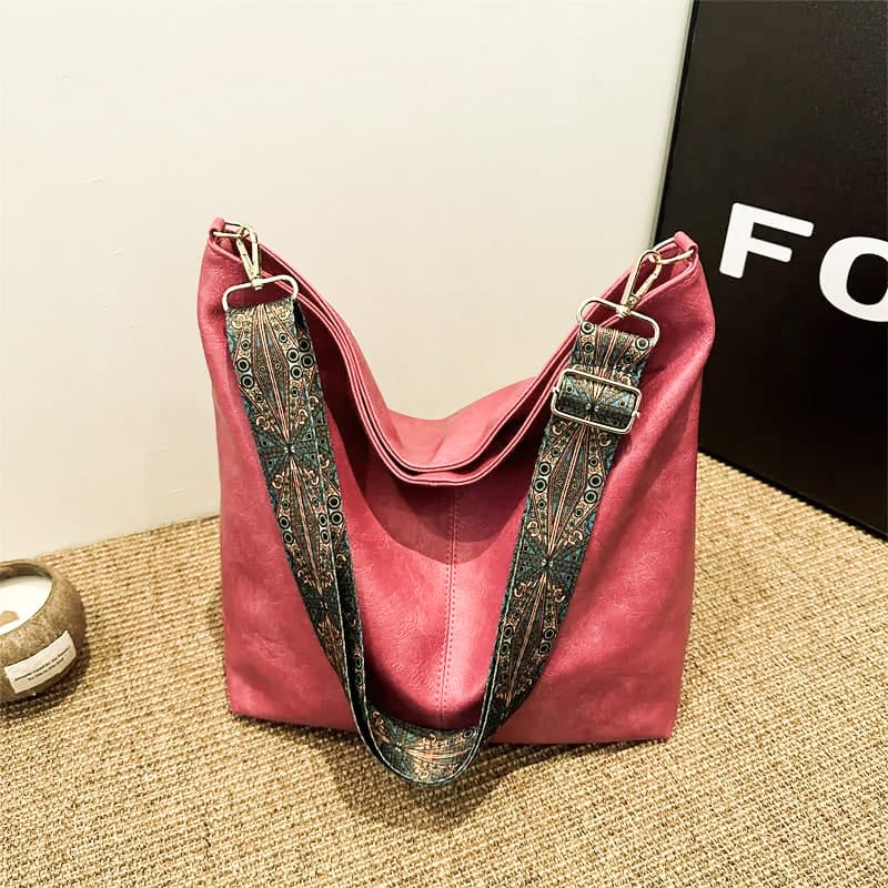 Vibrant pink TRENDBUY PU leather tote bag featuring a decorative patterned shoulder strap, placed on a woven mat.