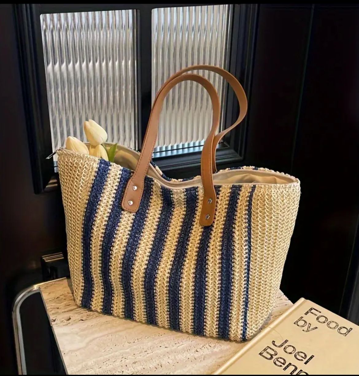Close-up of a blue striped jute tote bag with tulips, showcasing its texture and design on a table.