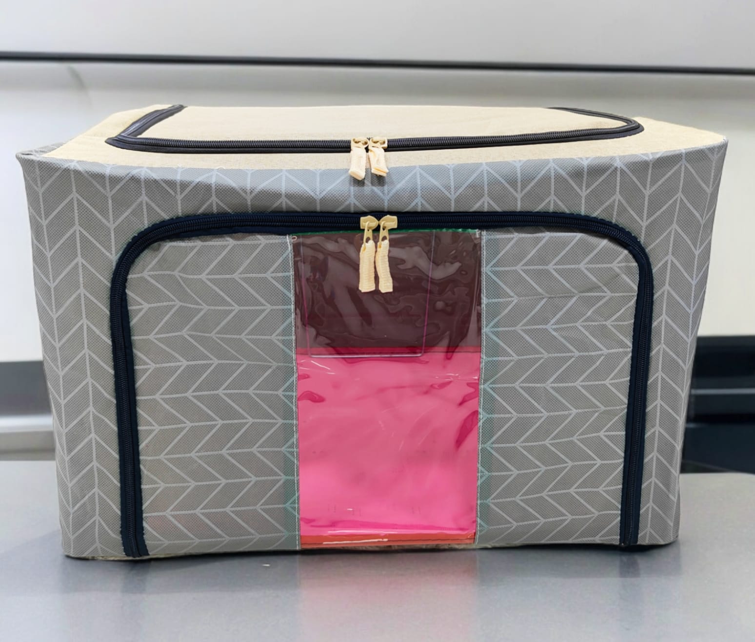Grey storage box with geometric arrow patterns, beige top, black zippers, showcasing the sturdy design.