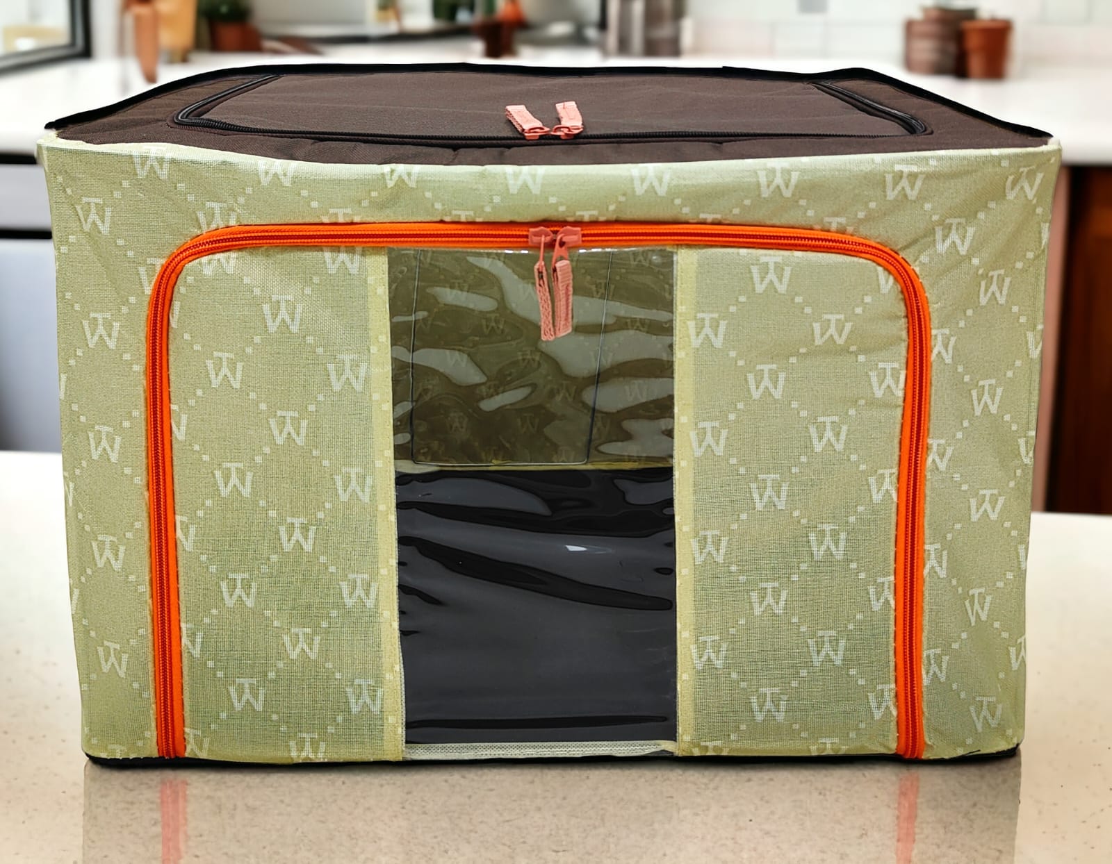 Light green patterned storage box with 'W' motif, brown top, orange zippers, professional product shot.