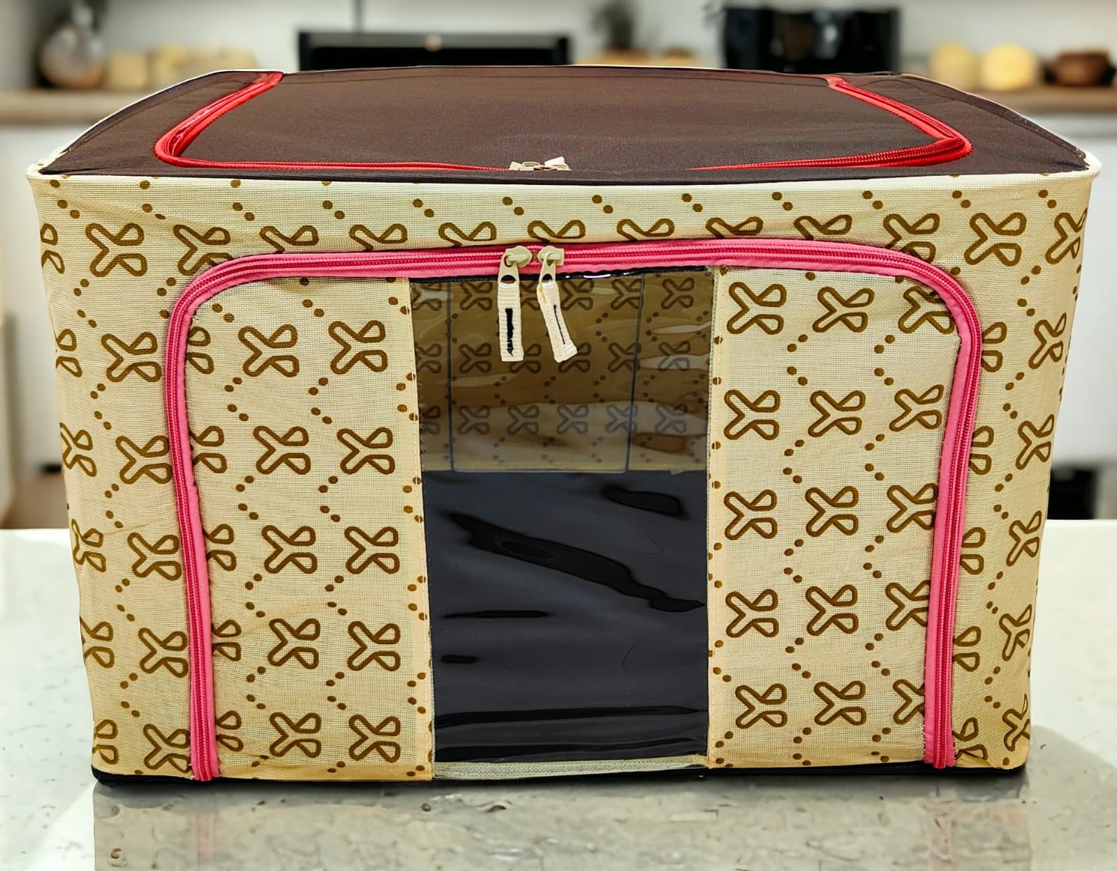 Beige patterned storage box with intricate brown motif, brown top, pink zippers, highlighting detailed pattern.