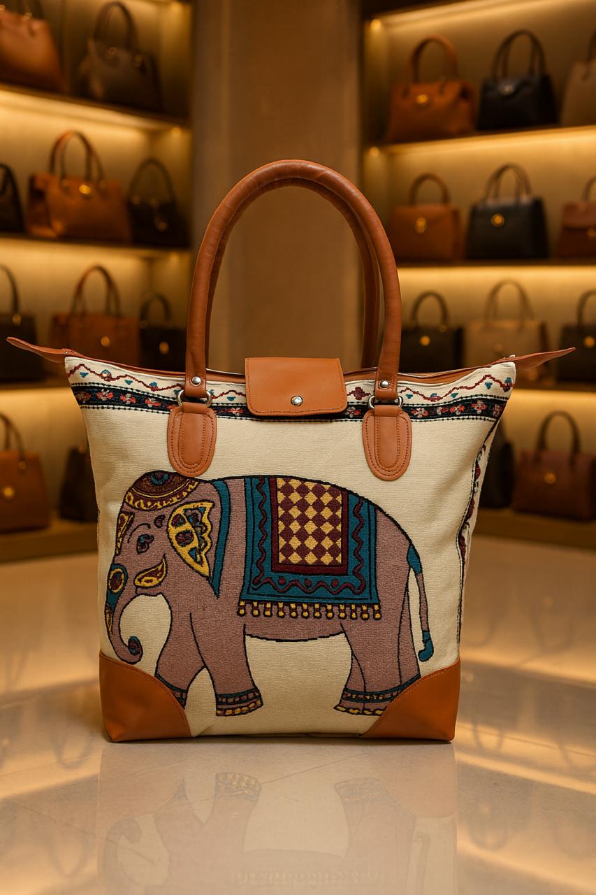 TRENDBUY cream canvas tote bag with a colorful, abstract elephant motif, featuring brown leather handles and a reinforced base.
