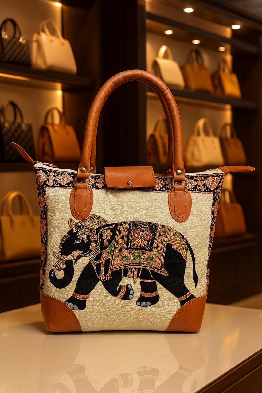 TRENDBUY cream canvas tote bag displaying a detailed black elephant in motion with ornate saddle and trunk designs, paired with contrasting brown leather accents.