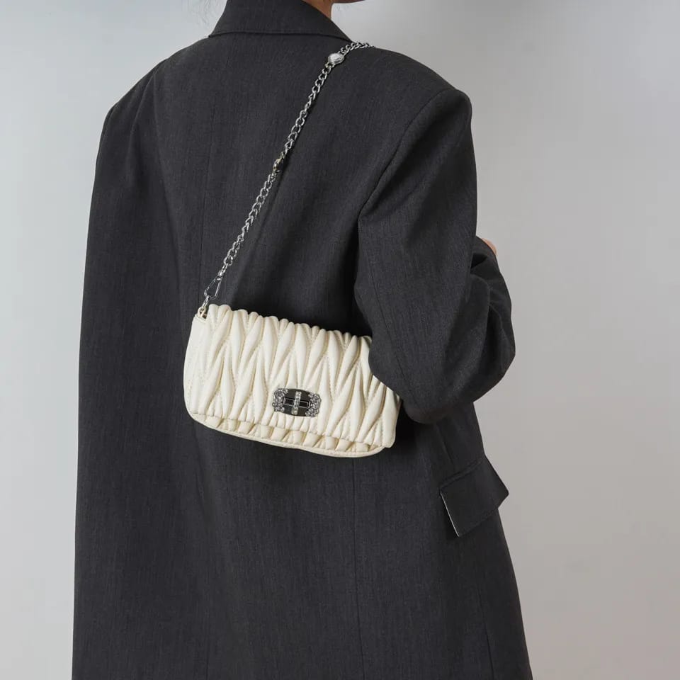 Back view of a person wearing the TRENDBUY cream white quilted sling bag as a crossbody, demonstrating its compact size and stylish fit.