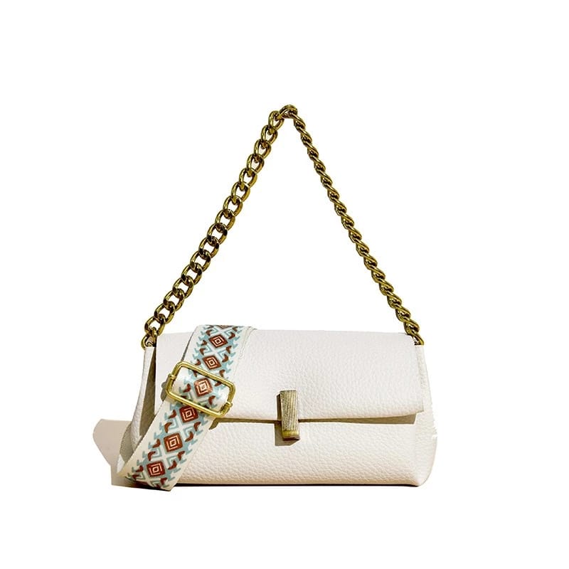 White TRENDBUY sling bag with a gold chain handle and a vibrant broad patterned strap, set against a pristine white background.