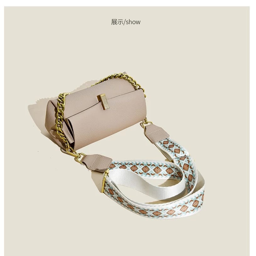 Angled view of the beige TRENDBUY sling bag, showcasing its elegant form and the comfortable, stylish broad patterned strap.