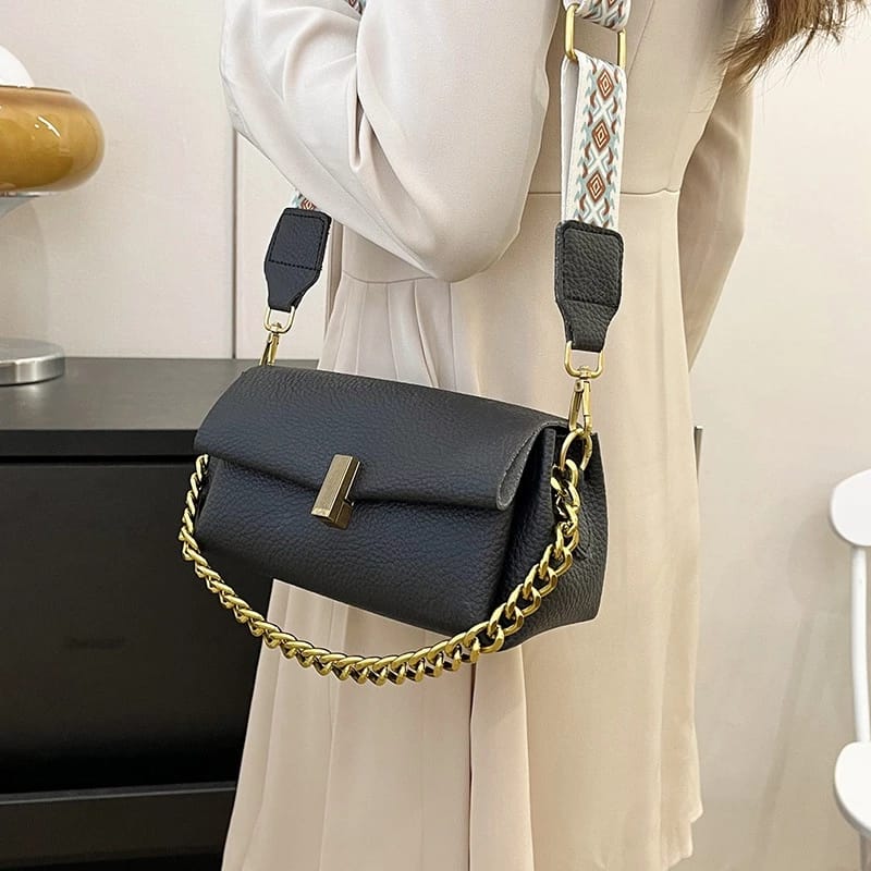Female model wearing the black TRENDBUY sling bag across her body, demonstrating its practical elegance and comfortable wear with the broad patterned strap.
