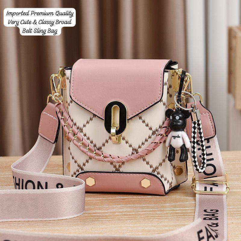 Elegant TRENDBUY pink and white broad belt sling bag with a matching 'FASHION BAG' strap, decorative chain, and a cute teddy bear keychain.