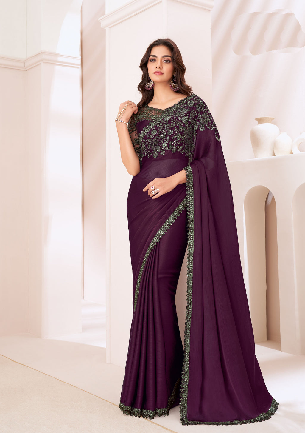 Model wearing a wine color partywear saree with an elegant designer blouse, perfect for festive occasions.