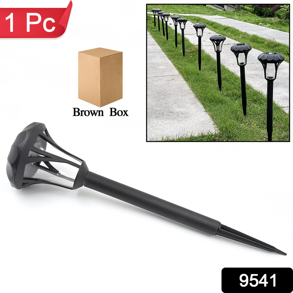 Low-profile round solar LED garden light illuminating a garden path at night with a warm glow.
