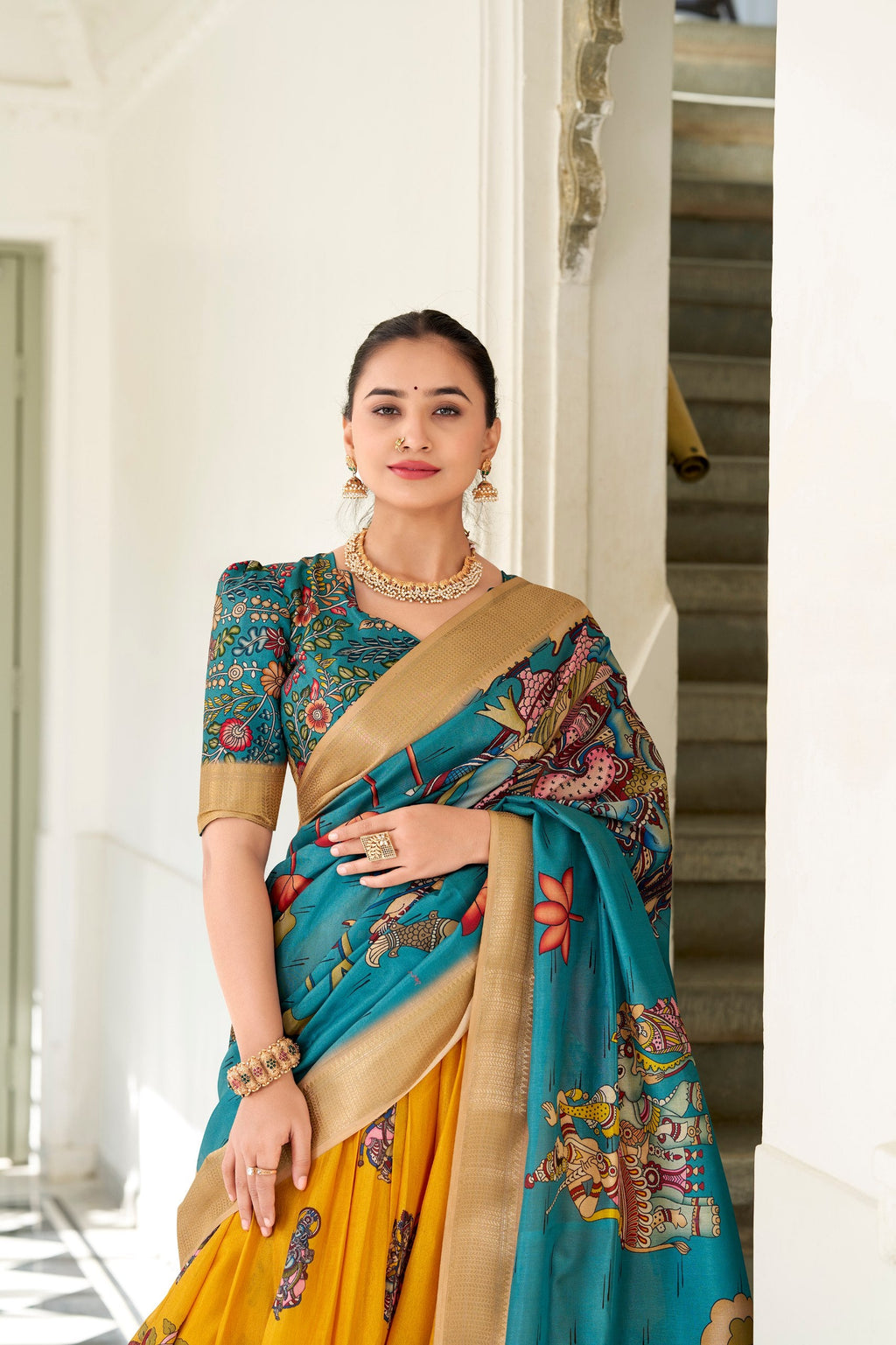 Close-up of the intricate traditional Kalamkari print motifs and woven gold zari border on the yellow silk fabric