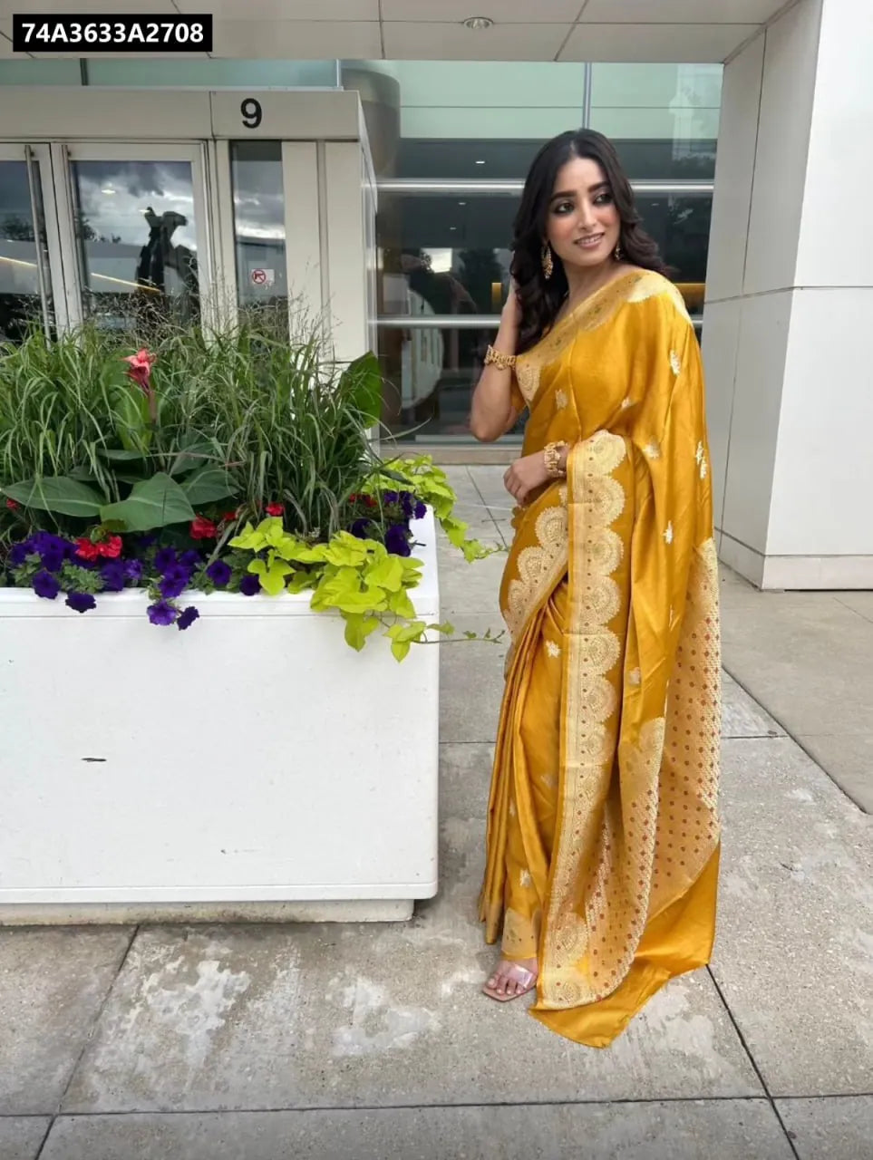 Model standing elegantly in a beautiful yellow Art Silk Jacquard Saree with a rich pallu.