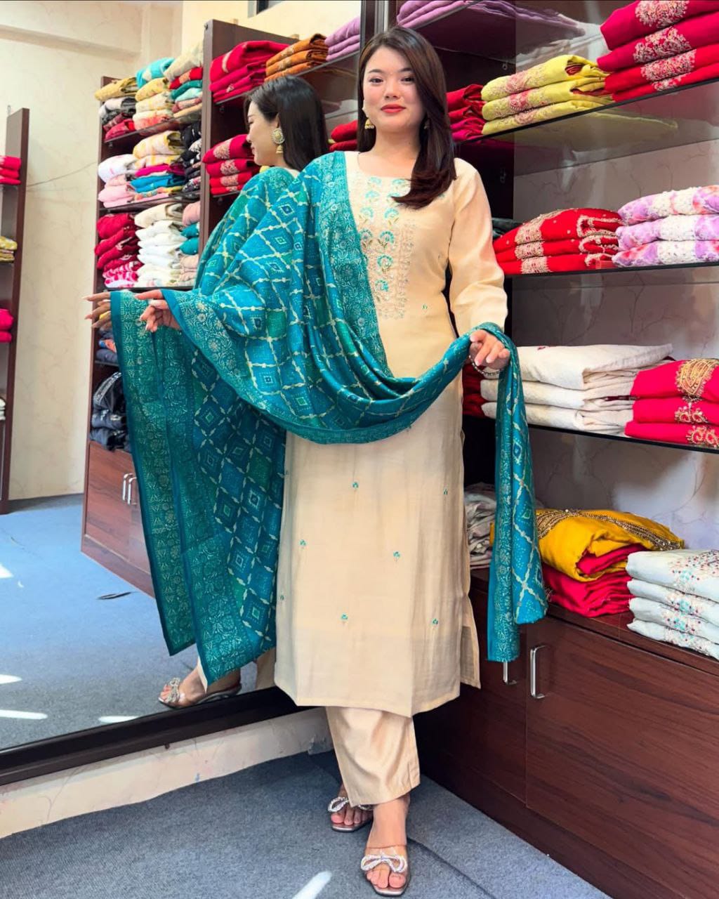 Model in cream kurti and teal/blue Banarasi Bandhej dupatta, full shot