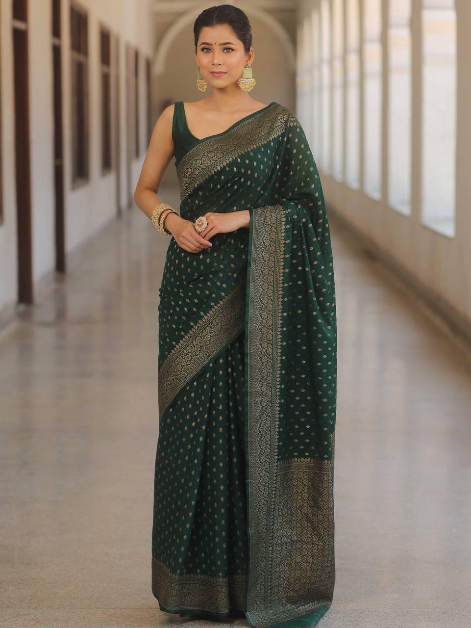 Model in elegant dark green Banarasi Soft Silk Saree with traditional Zari work and Jacquard weave.