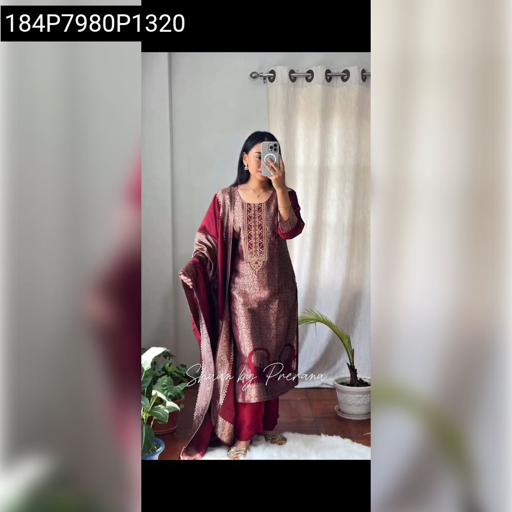 Model wearing full Banarasi Zari Weaving Suit Set in maroon and gold, posing front-facing with phone.