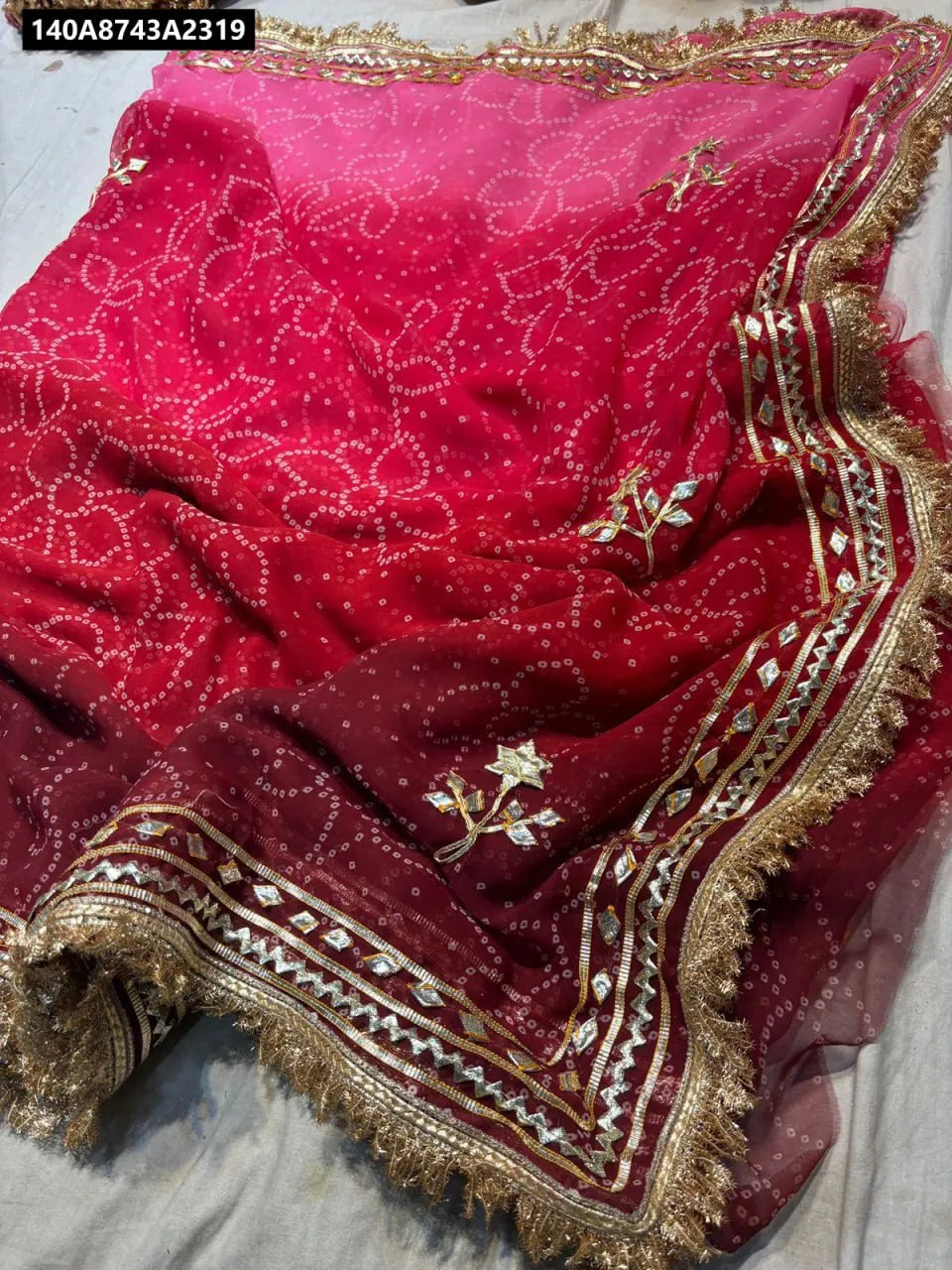 Red and pink ombre Bandhej georgette saree with heavy handwork, gota patti, and cut dana detailing by TRENDBUY
