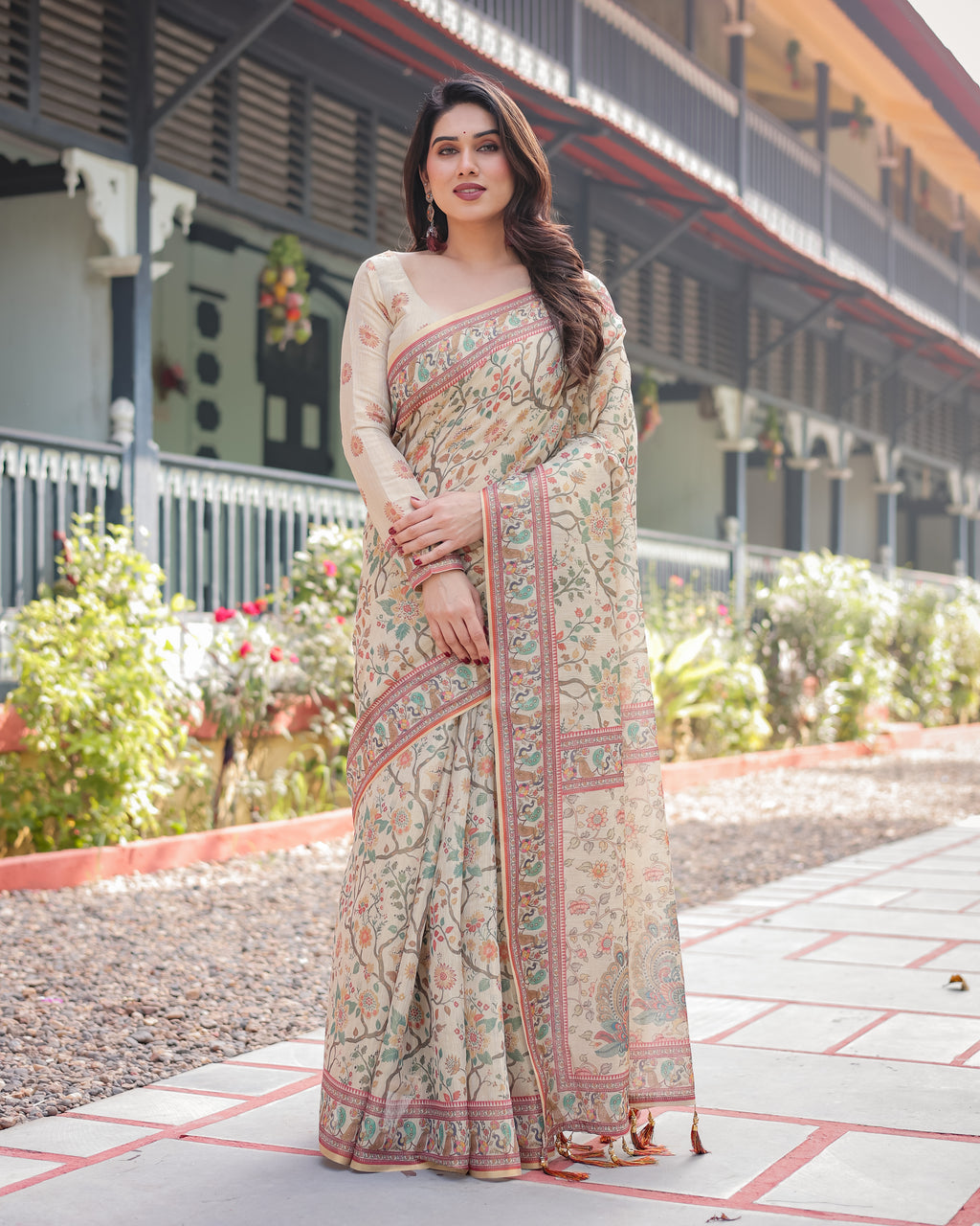 Full shot of woman wearing beige floral handloom saree, front view, in an outdoor setting