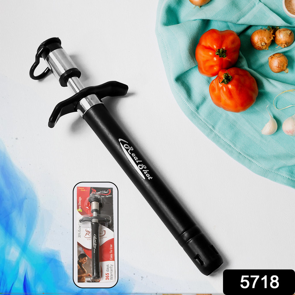 Stainless steel gas lighter igniting a kitchen gas stove burner.