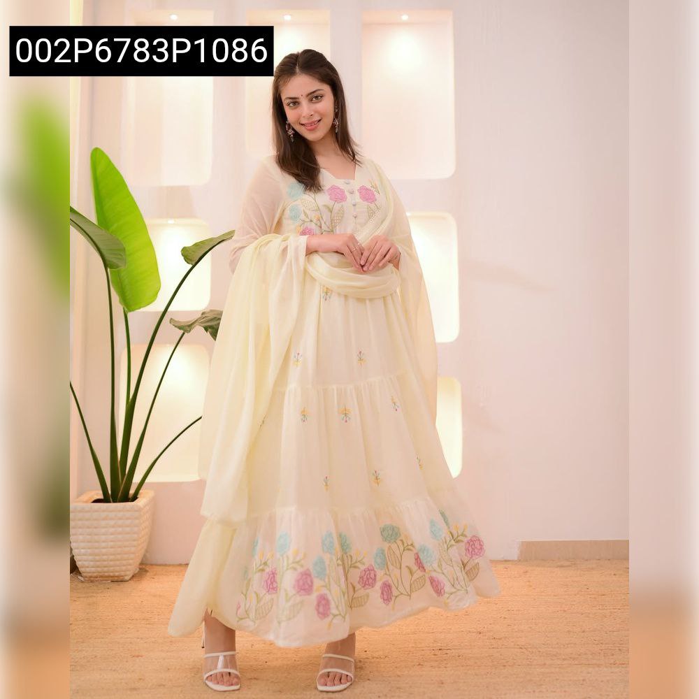Full shot of a model wearing a light cream Chanderi tiered Anarkali suit with colorful floral embroidery, posing gracefully.