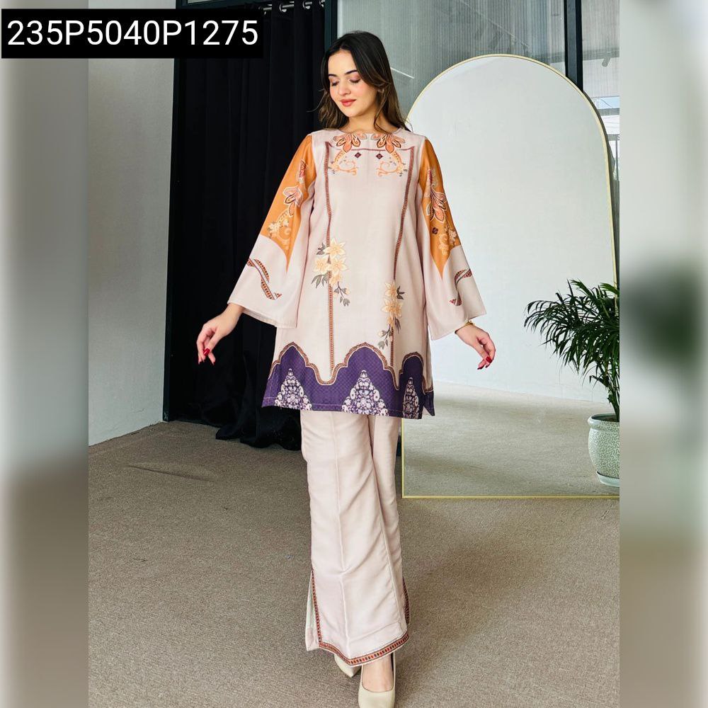 Model posing in a light beige and orange printed viscose rayon short kurti and pant set, front view.