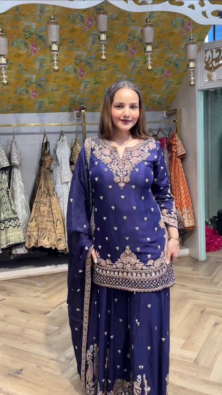 Full body shot of a woman in navy blue sequence embroidered Chinon plazzo suit, smiling.