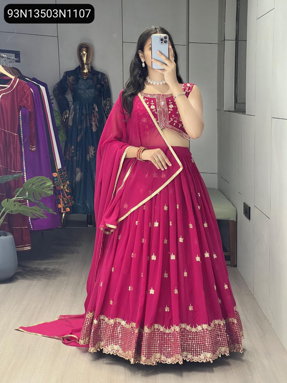 Full body front view of a model in a vibrant rani pink embroidered georgette lehenga, displaying the full ensemble with traditional elegance.