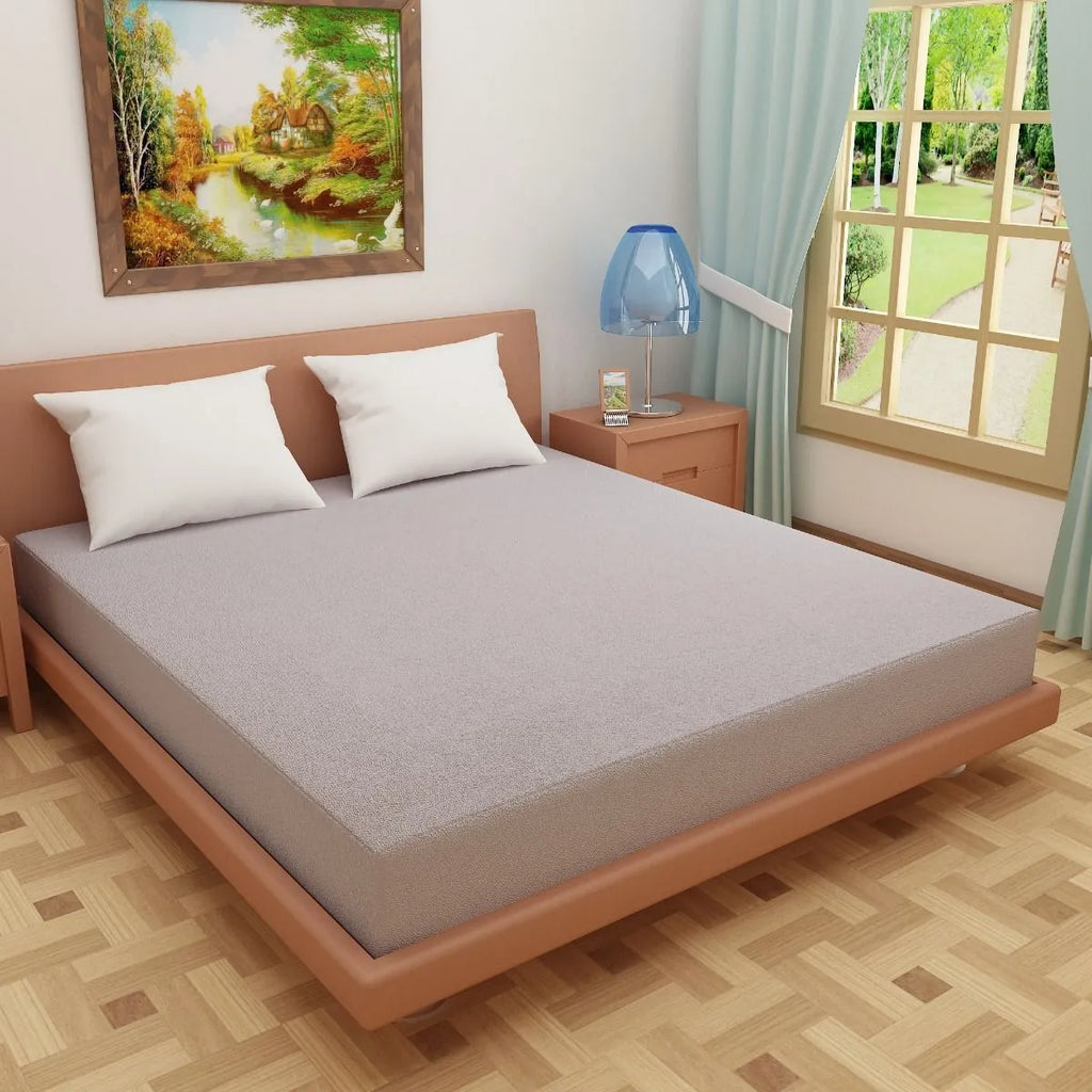 Grey solid heavy terry fitted mattress protector on king size bed