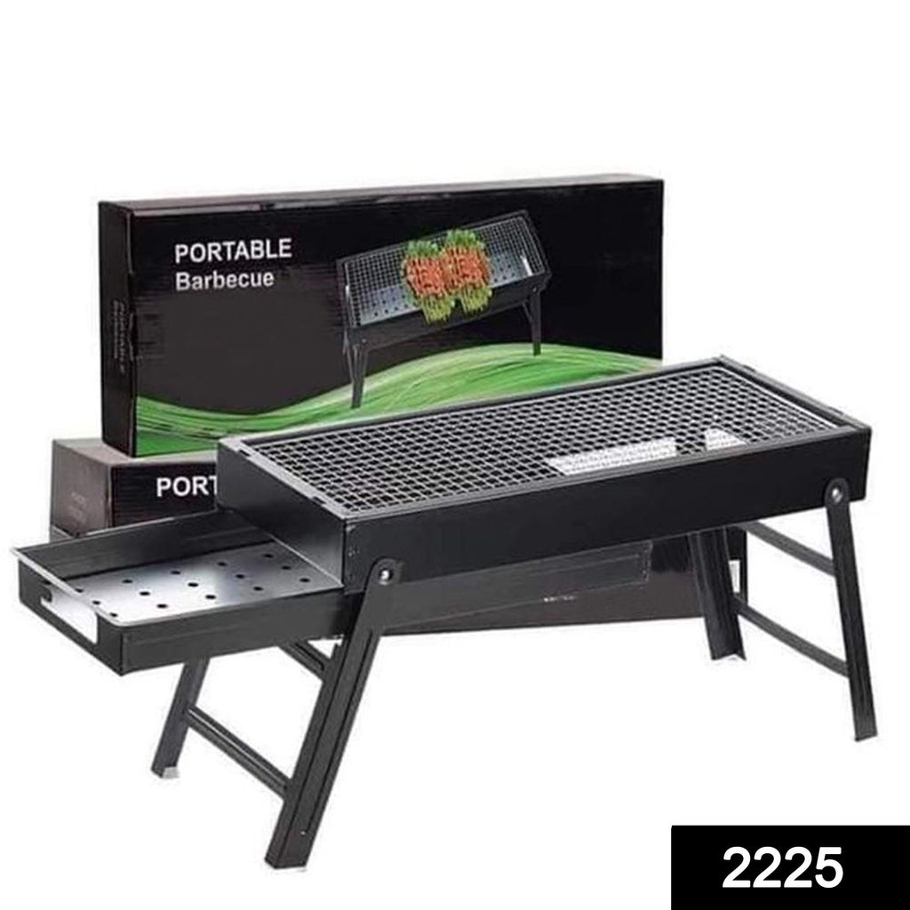 Portable folding BBQ grill set in use outdoors, cooking food on skewers.