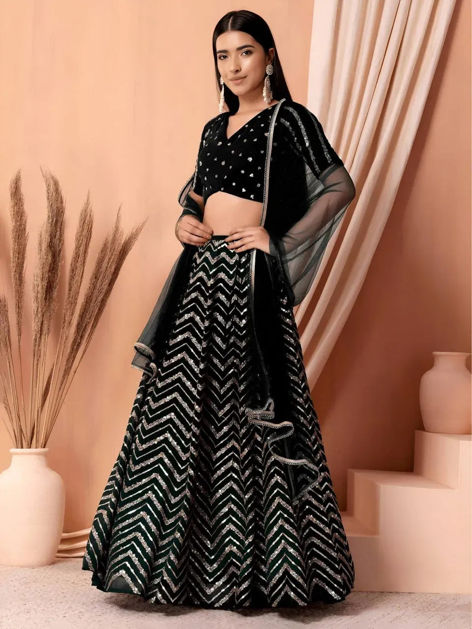 Full body shot of model wearing black chevron sequin lehenga with net dupatta