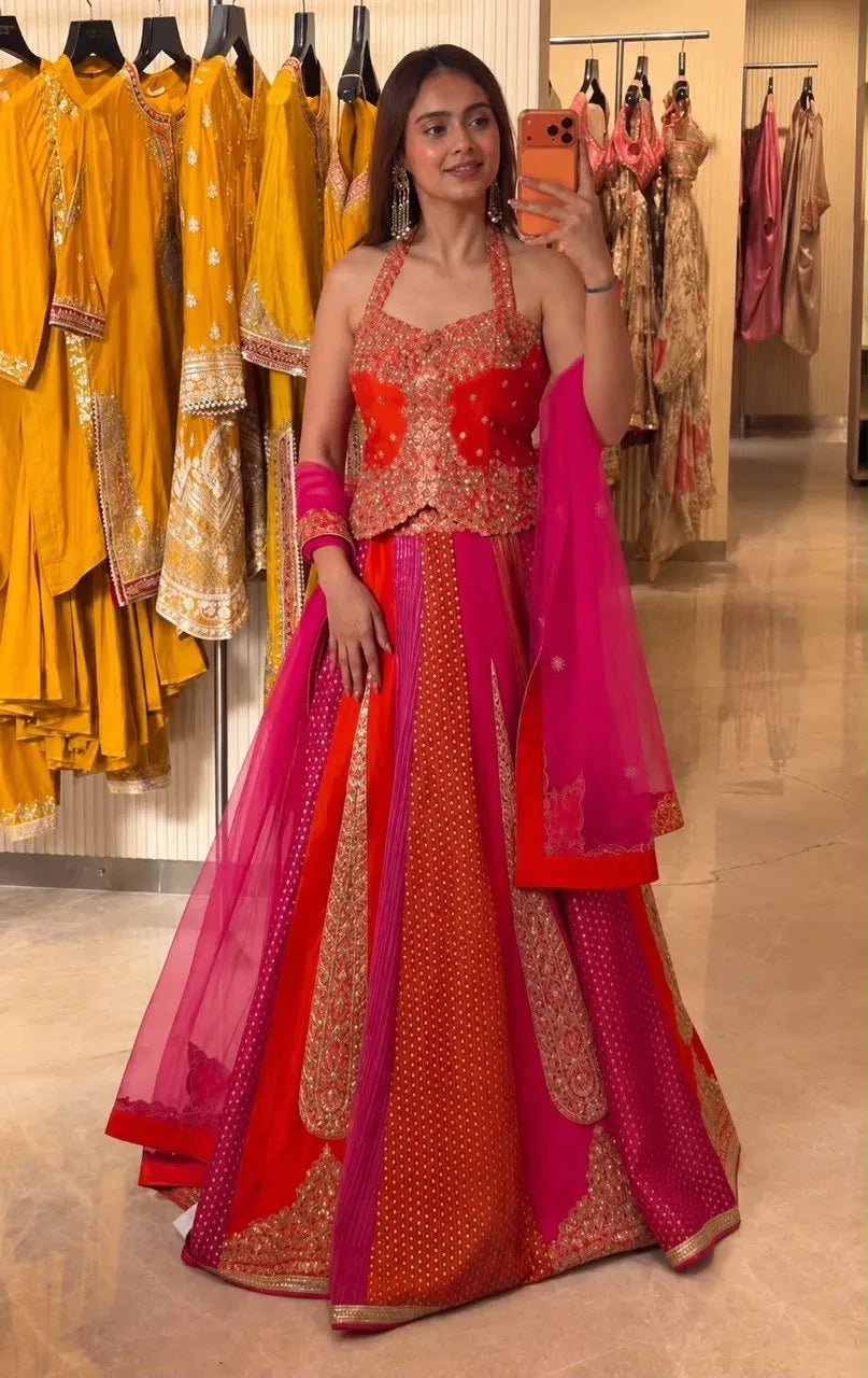 Woman posing with phone in a multi-colored embroidered Chinon silk lehenga set