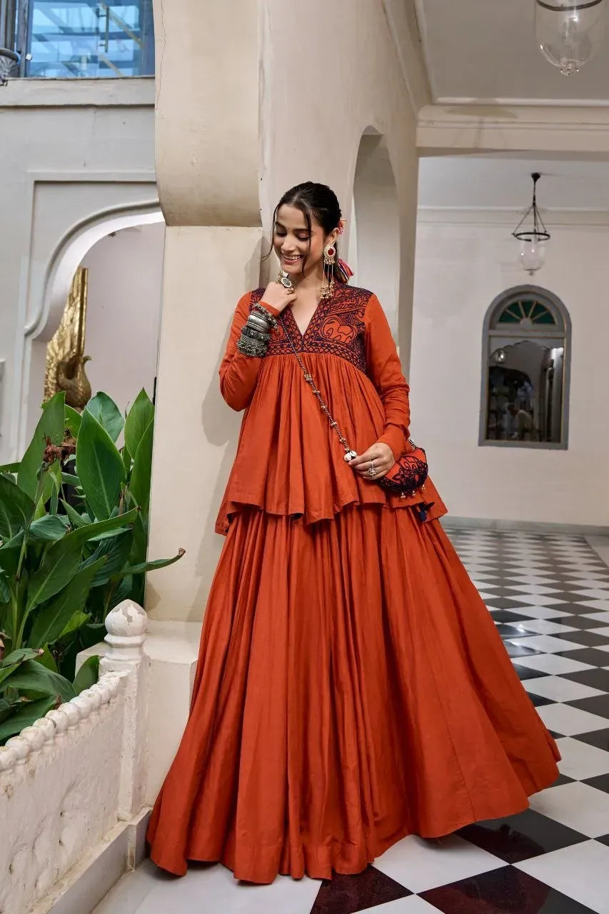 Model wearing rust orange pure cotton lehenga with gamthi work top and matching purse