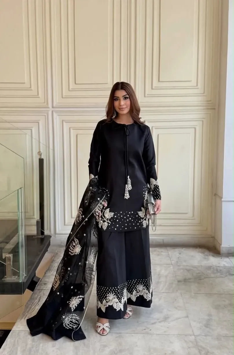 Model wearing a black crepe top and palazzo set with heavy embroidery