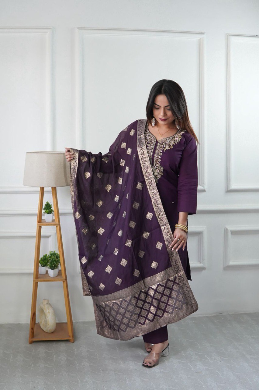 Woman posing in a plum purple designer embroidered silk suit set with fancy dupatta from TRENDBUY