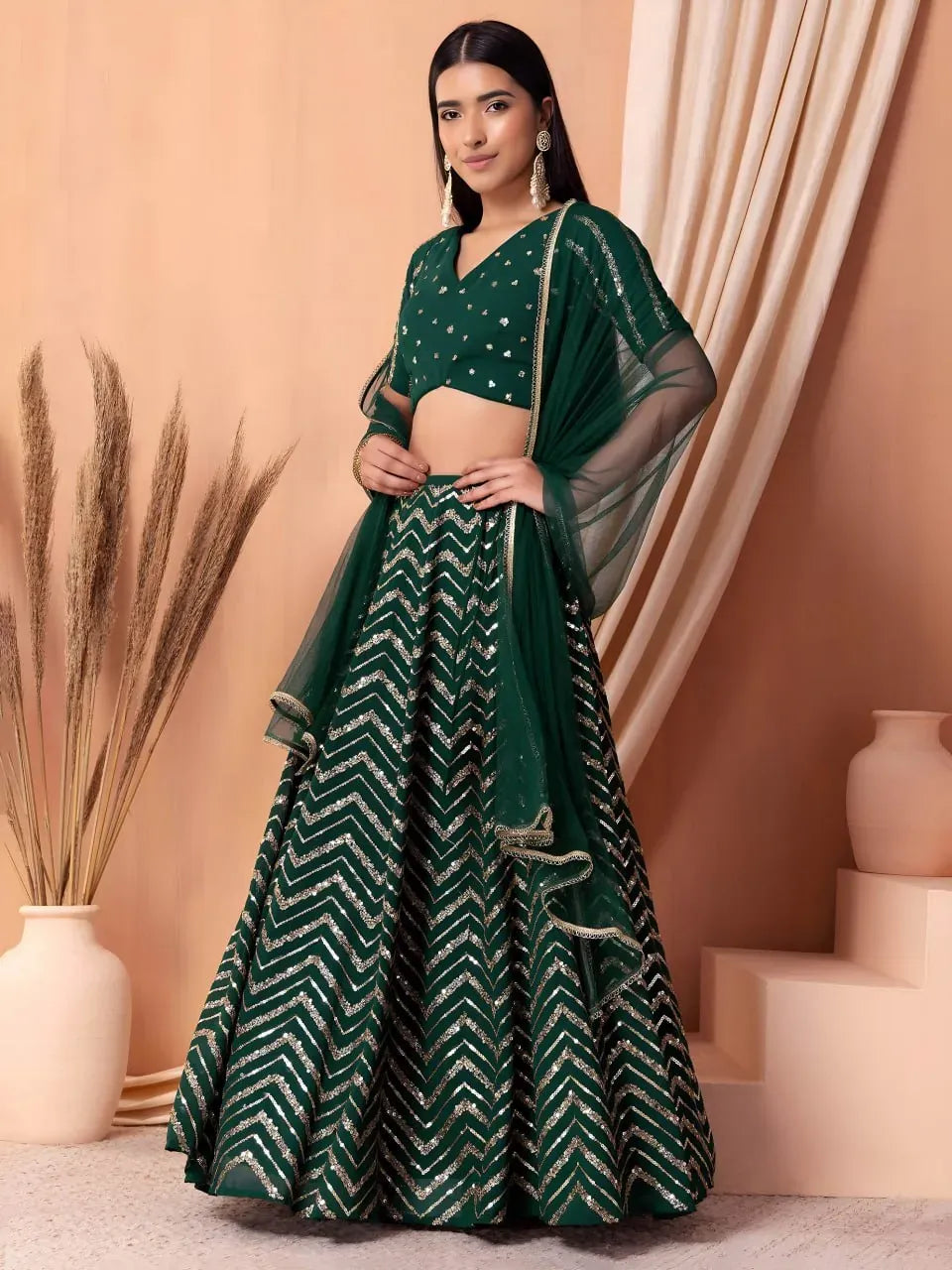 Front-facing full body shot of model wearing emerald green chevron lehenga choli with dupatta