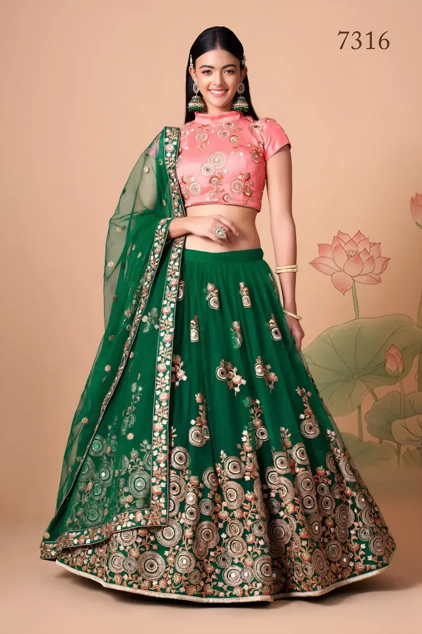 Front view of model wearing emerald green net lehenga with pink blouse and dupatta