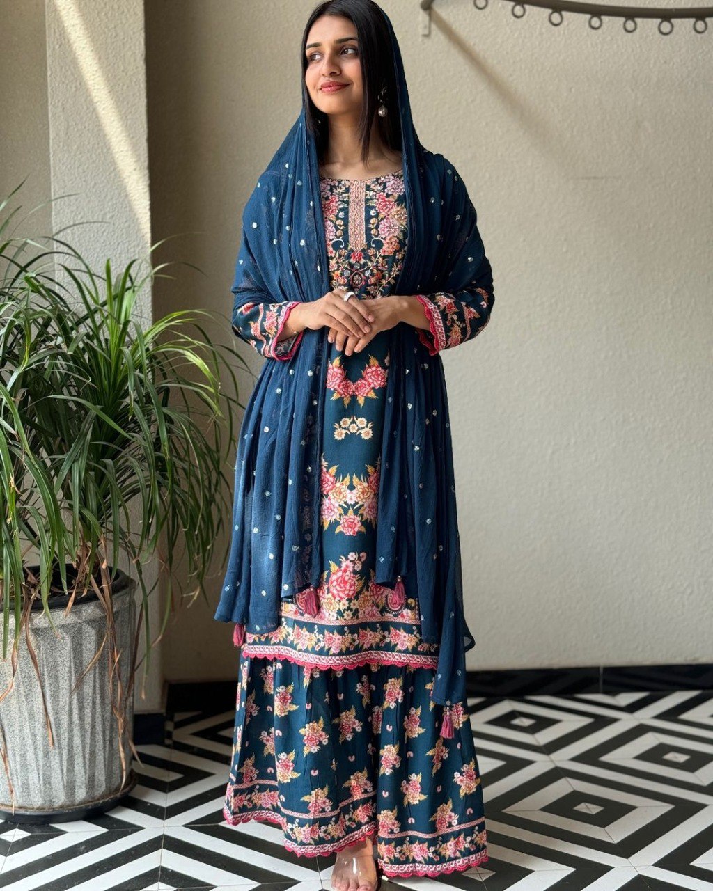 Woman posing in a Designer Floral Digital Print Rayon Suit with a matching Georgette dupatta, showcasing the intricate handwork.
