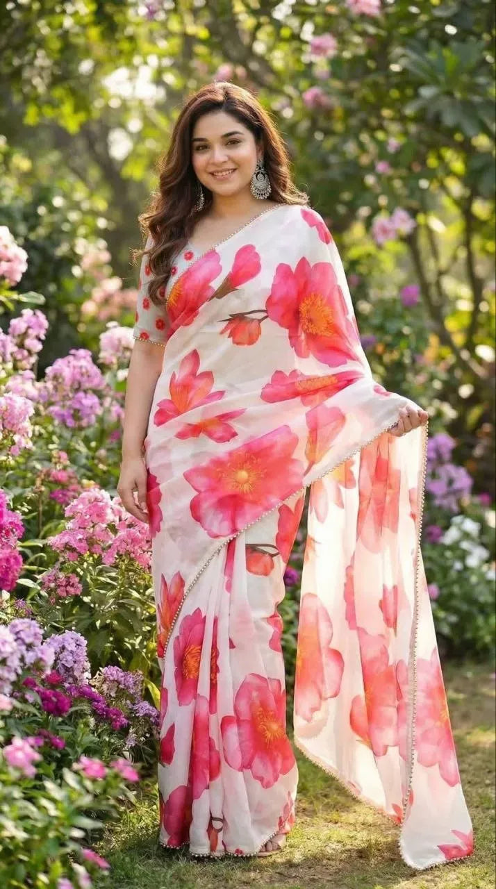 Full body shot of model in white floral digital print saree standing near flowers