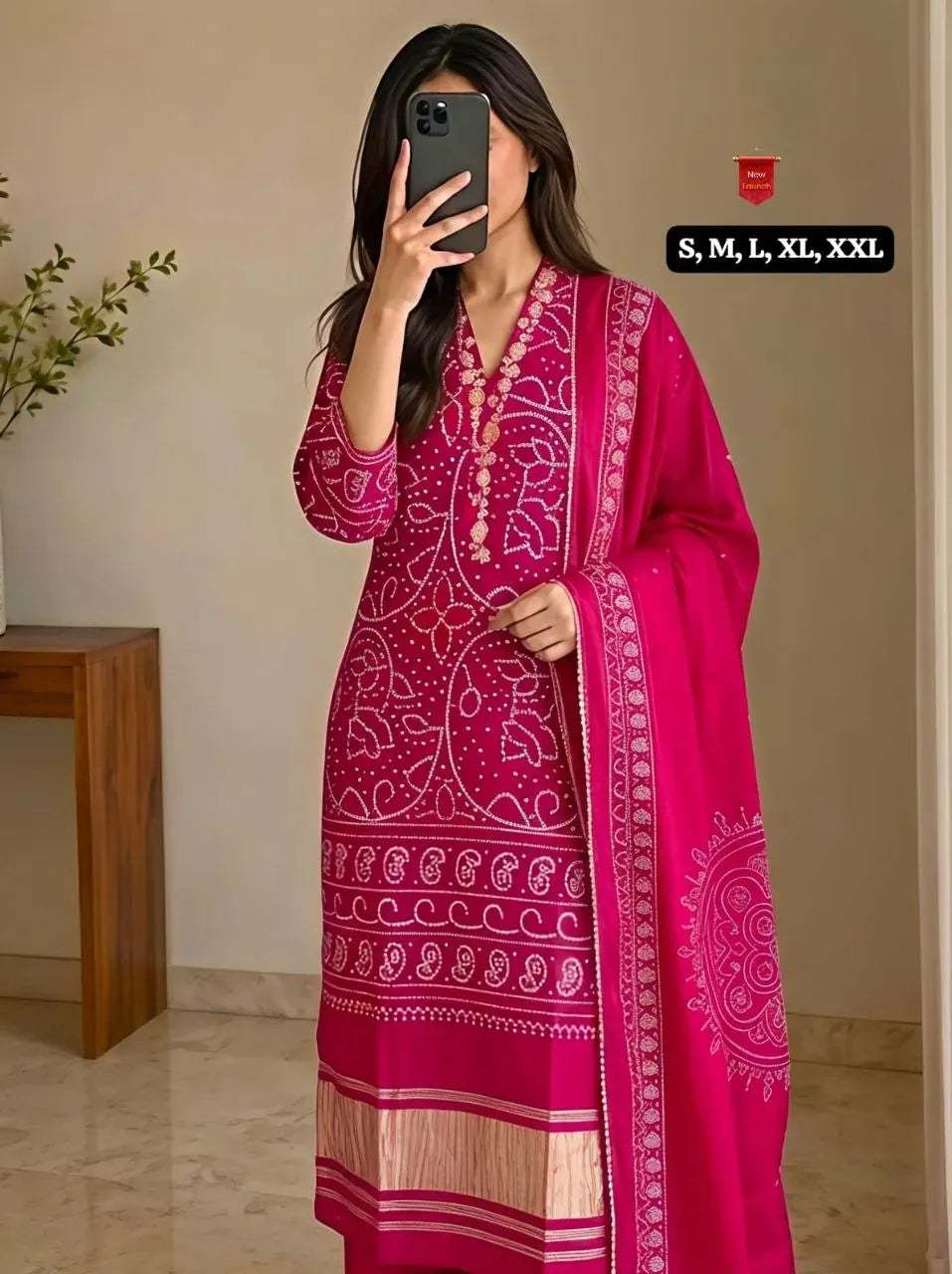 Woman wearing pink embroidered kurti set with dupatta taking mirror selfie