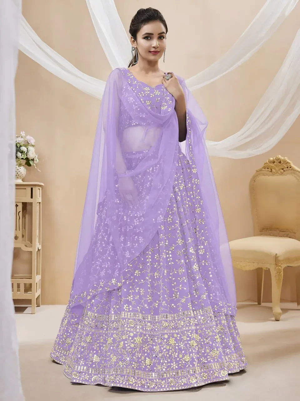 Full view of model wearing lavender lehenga choli with sheer net dupatta