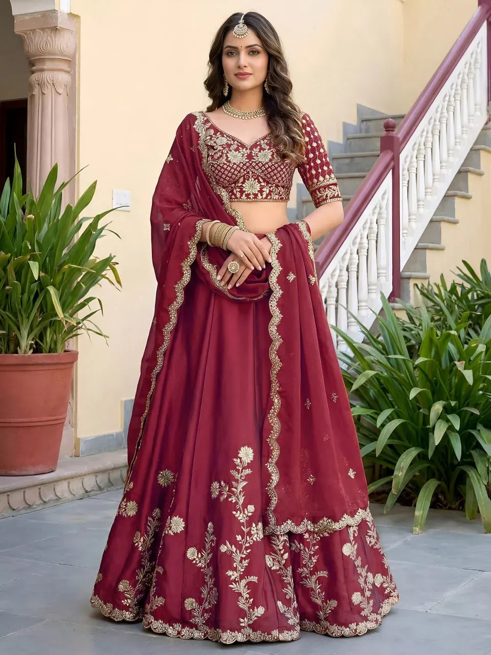 Model wearing rich maroon embroidered lehenga choli with dupatta