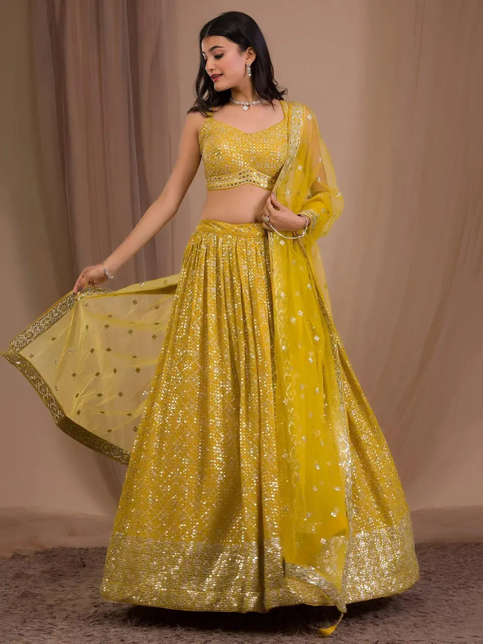 Model wearing mustard yellow georgette lehenga choli with sequin work and dupatta front view